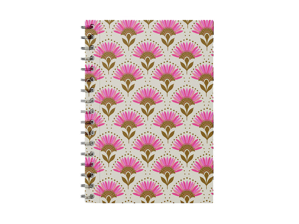 Photo shows a notebook on a white background. The notebook has a modern, geometric floral pattern in shades of bright pink and vibrant mustard yellow. It has a slight art deco inspiration and is a lovely stationery piece for making each day feel special.
