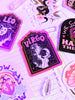 Sticker SEO:  A collection of zodiac stickers sits on a white background with purple aura glow lights. There are illustrated stickers of each astrological sign, with a retro hand lettering spelling out the name of each sign. Stickers for Aries, Taurus, Cancer, Gemini, Leo, Virgo, Libra, Scorpio, Sagittarius, Capricorn, Aquarius, and Pisces. Water sign, Fire Sign, Earth Sign, Air Sign. Surrounded by clear quartz crystals. Witchy. Witch. Boho. Bohemian. Astrology Girlie. Yoga. Yogi.